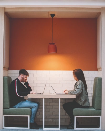 Two staff working opposite one another in a booth.
